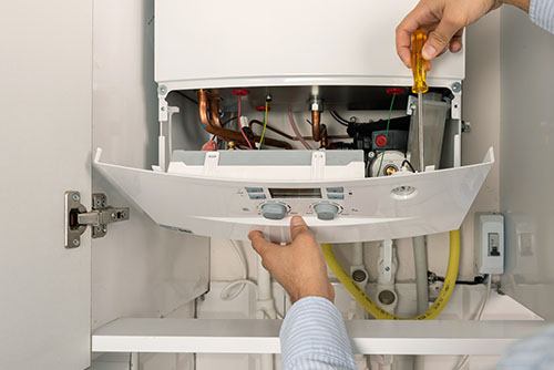 HVAC technician repairing an indoor boiler in Goodyear