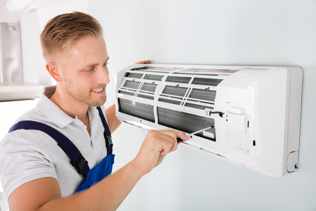 HVAC technician performing ductless air conditioning maintenance in Goodyear