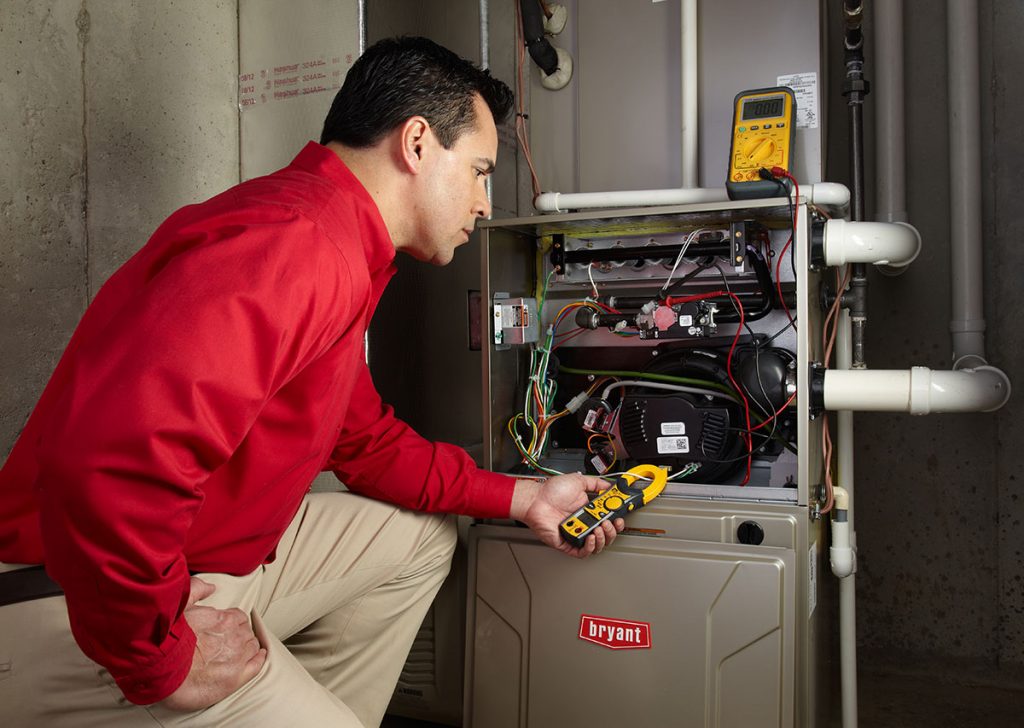 HVAC technician repairing an indoor furnace in Goodyear