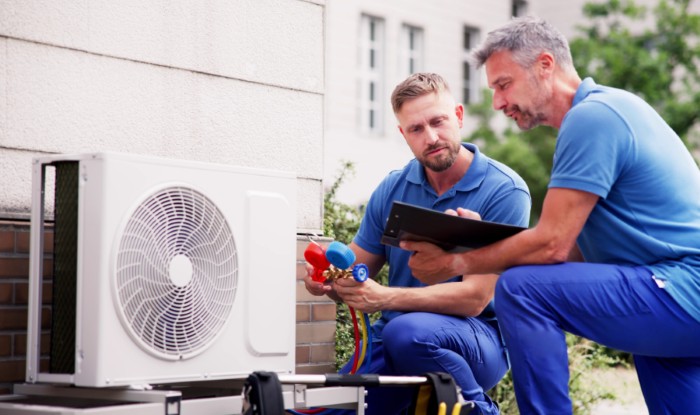 HVAC technicians installing an outdoor air conditioning unit in Goodyear