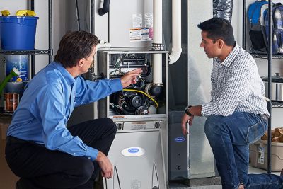 65df8c11f3e4c468cbd351a5_furnace repair vs replacement – Copy HVAC technician explaining furnace repair and maintenance to a homeowner in Goodyear, AZ