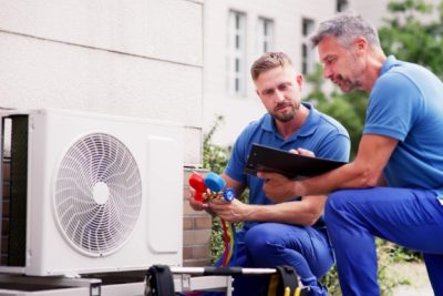 ac-installation-in-claremont-ca HVAC technicians reviewing an outdoor air conditioning unit in Goodyear, AZ