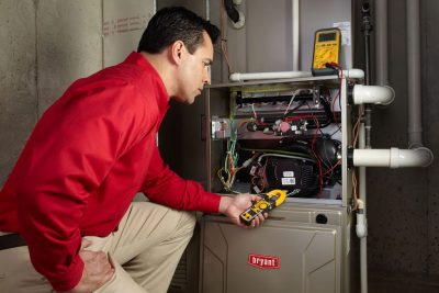 furnace repair Heating and air conditioning technician servicing an indoor furnace in Goodyear, AZ